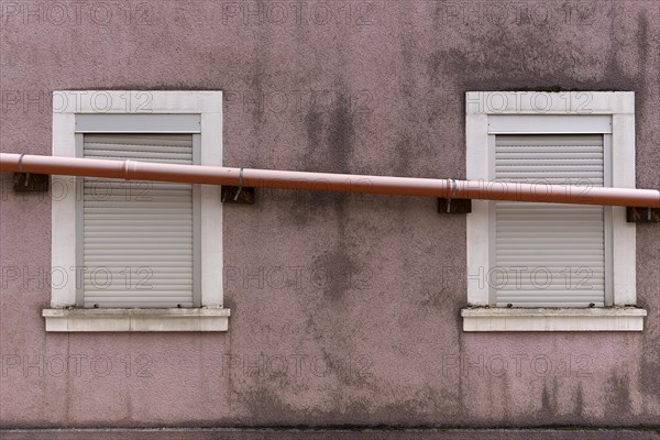 Drain pipe runs across the windows of a single-family house