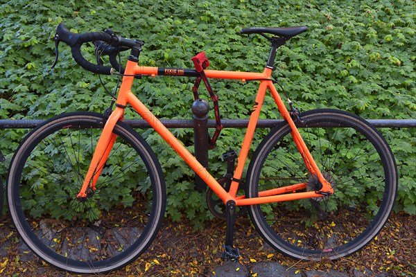 Red racing bike secured with a lock on the railing