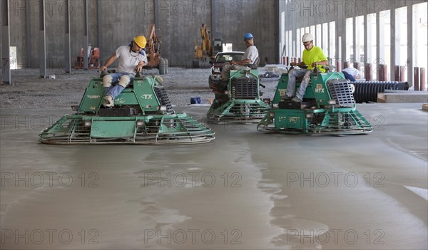 Riding Power Trowels over freshly poured concrete can smooth the surface to a glasslike finish