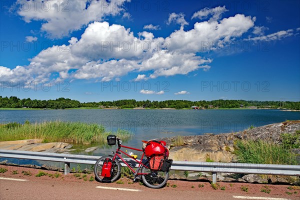 Bicycle with luggage leaning against a guard rail