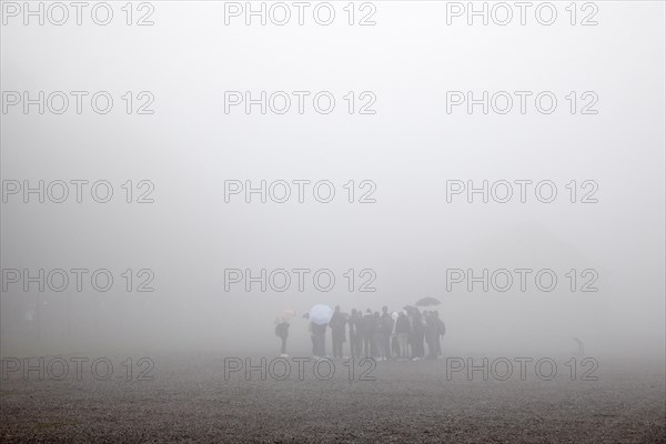Group of visitors in the fog at beech forest concentration camp