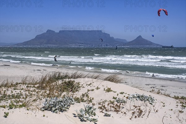 Table Mountain and kitesurfers at Bloubergstrand along the Atlantic Ocean shores of Table Bay near Cape Town