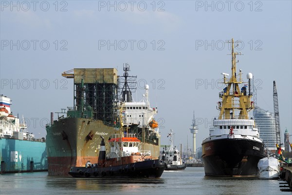 The cargo ship Sandpiper from Panama is guided by two tugs to the berth in the connecting port