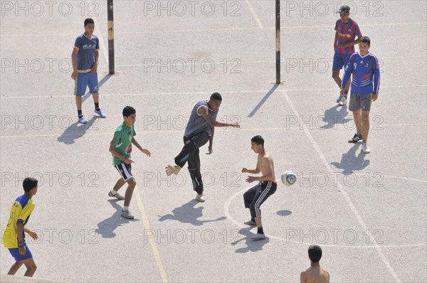 Young people playing football on a football pitch