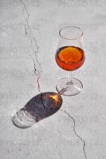 Glass of brandy on concrete background