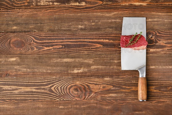 Piece of raw beef brisket flat steak on butcher's cleaver with place for text