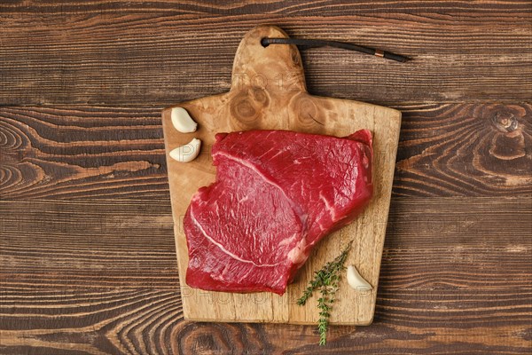 Top view of raw top side beef steak on wooden tabletop