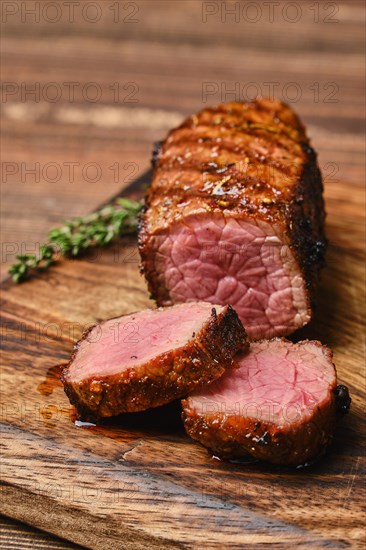 Closeup view of juicy roasted beef brisket flat steak on wooden cutting board