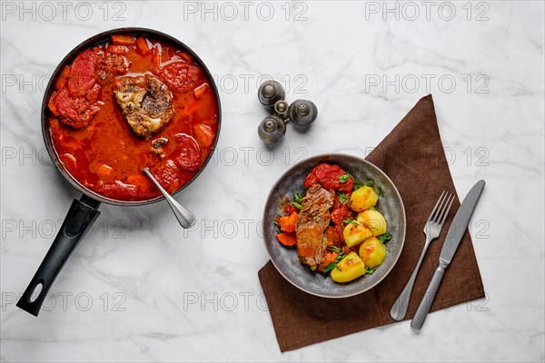 Slow cooking food. Top view of bottom round roast beef meat baked in beer gravy with tomatoes and carrot