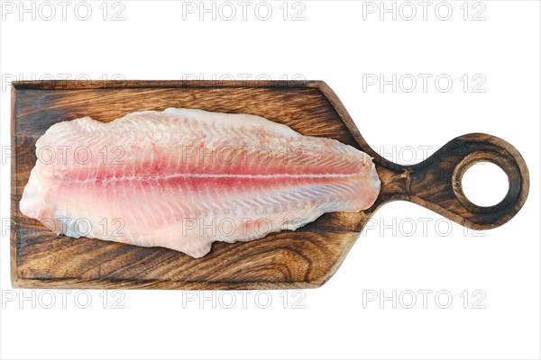 Top view of fresh raw fillet of pangasius on wooden cutting board isolated on white background