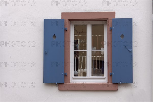Window with blue shutters and kitchen utensils as decoration