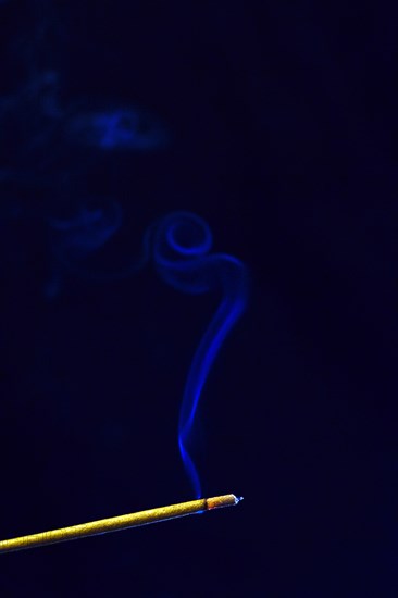 Blue smoke plume from an incense stick