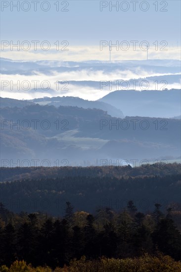 View from Moerschieder Burr mountain in the Hunsrueck-Hochwald National Park over the Naheland and North Palatinate mountains on a misty autumn morning