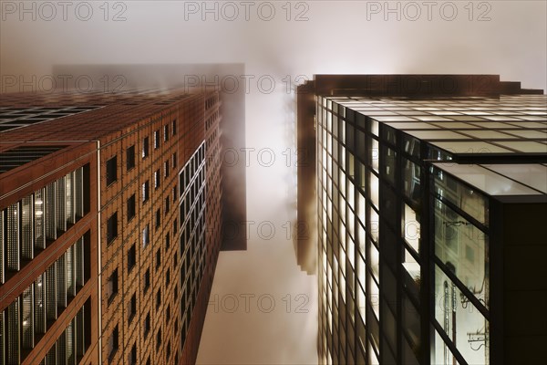 Illuminated skyscrapers in the fog at night