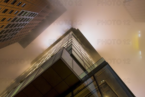 Illuminated skyscrapers in the fog at night