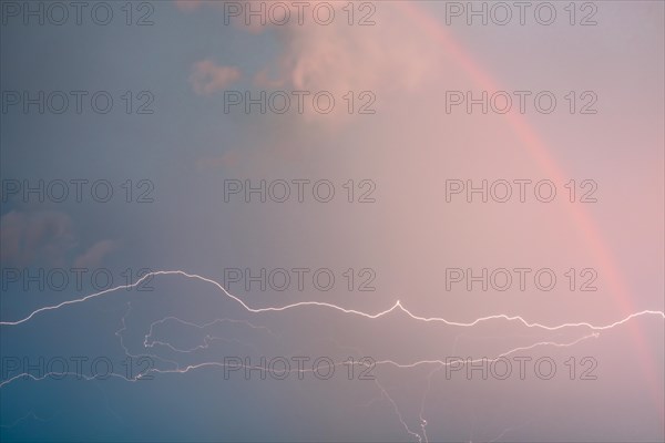 Electric lightning and rainbow in a storm cloud. Alsace