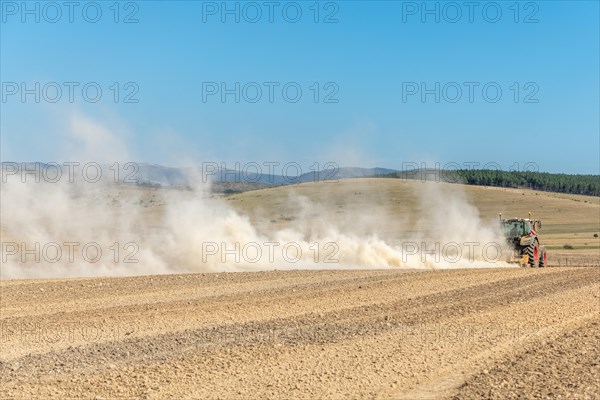 Dust cloud lifted by a tractor in times of drought. Cevennes