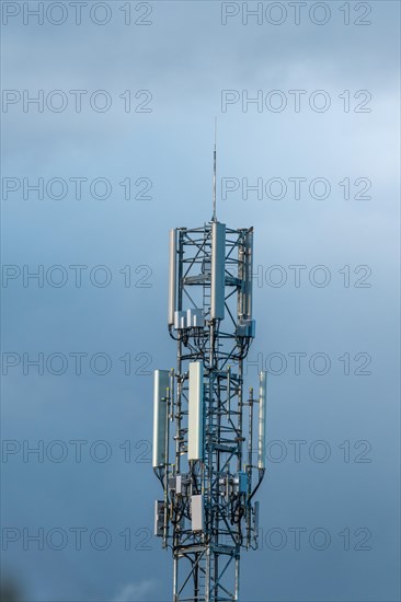Telecommunication antenna in a village in the countryside in cloudy weather. Alsace