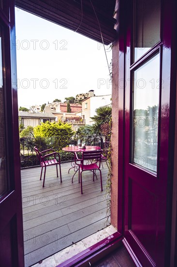 Red metal table on a terrace of a garden of a Mediterranean-style house in the province of Gerona in Catalonia Spain