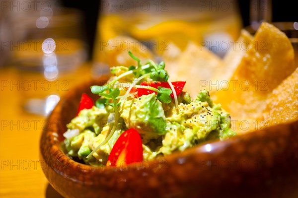 Fresh avocado and shrimps salad with nachos on side