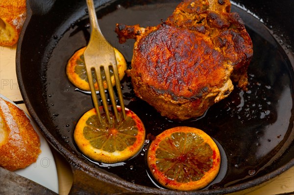 Pork chop seared on iron skillet with lemon and spices seasoning