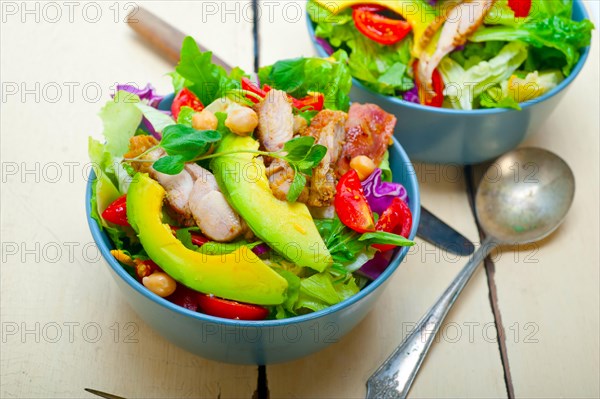 Fresh and healthy Chicken Avocado salad over rustic wood table