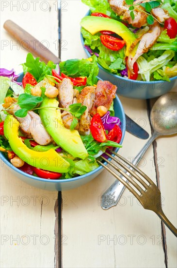 Fresh and healthy Chicken Avocado salad over rustic wood table