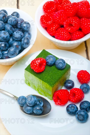 Green tea matcha mousse cake with raspberries and blueberries on top