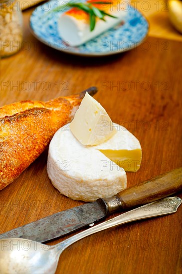 French cheese and fresh baguette on a wood cutter