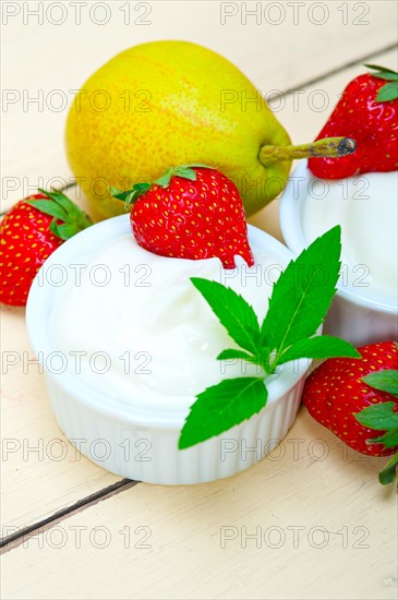 Fresh fruits and whole milk yogurt on a rustic wood table