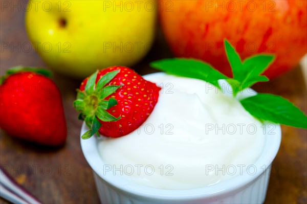 Fresh fruits and whole milk yogurt on a rustic wood table