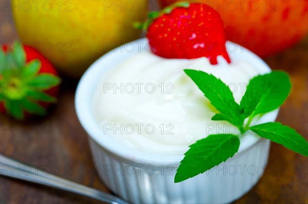 Fresh fruits and whole milk yogurt on a rustic wood table