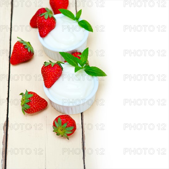 Organic Greek yogurt and strawberry over white rustic wood table