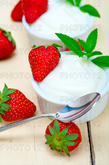 Organic Greek yogurt and strawberry over white rustic wood table