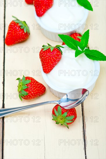 Organic Greek yogurt and strawberry over white rustic wood table