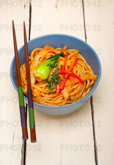 Hand pulled stretched Chinese ramen noodles on a bowl with chopstick