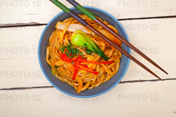 Hand pulled stretched Chinese ramen noodles on a bowl with chopstick