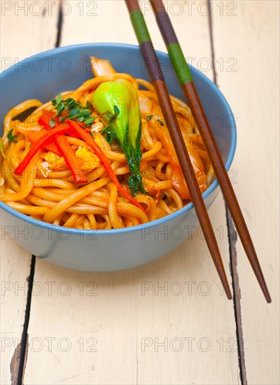 Hand pulled stretched Chinese ramen noodles on a bowl with chopstick