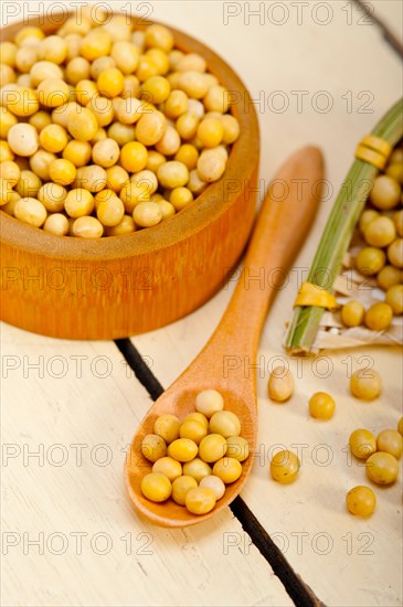 Organic soya beans over rustic wood table macro closeup