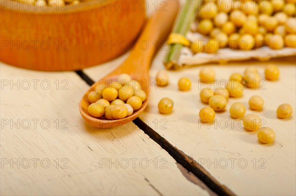 Organic soya beans over rustic wood table macro closeup