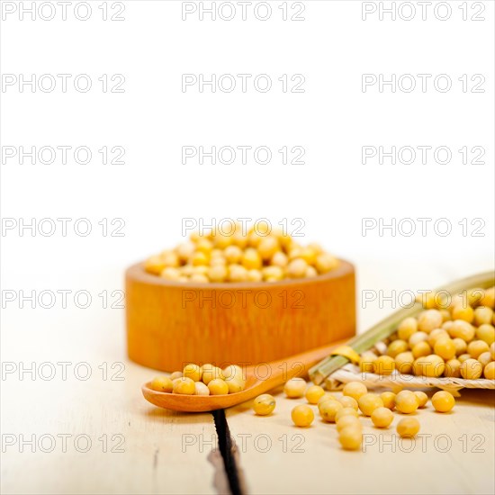 Organic soya beans over rustic wood table macro closeup