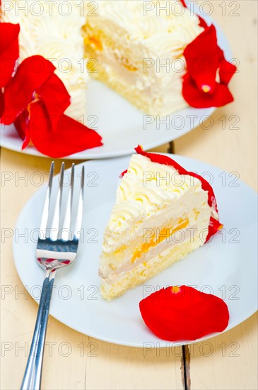 Whipped cream mango cake with red rose petals