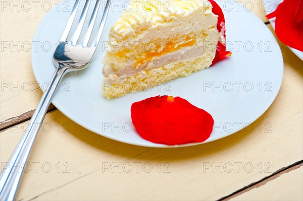 Whipped cream mango cake with red rose petals