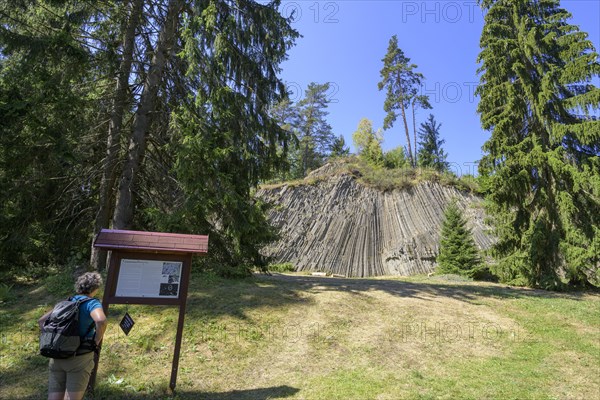 Woman standing in front of a display board at the basalt rock Rotavske varhany