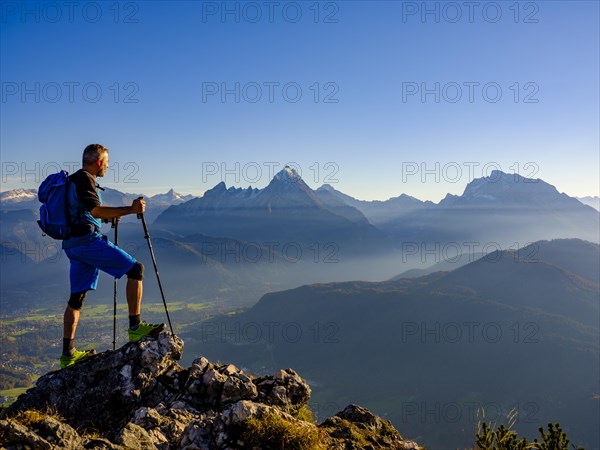 Mountaineer at the summit Rauher Kopf looking at the Berchtesgaden Alps