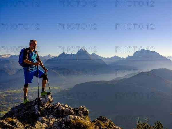 Mountaineer at the summit Rauher Kopf looking at the Berchtesgaden Alps