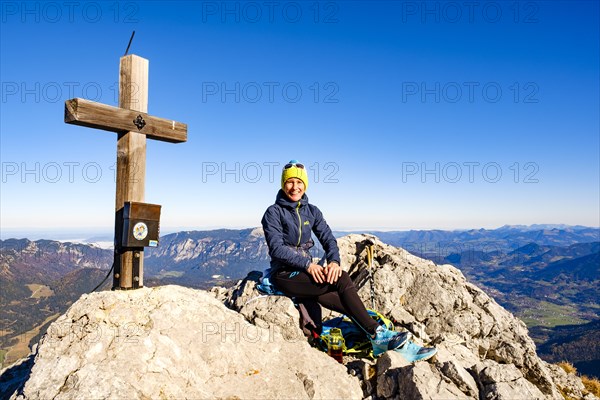 Mountaineer taking a break at the summit cross of the Schaertenspitze