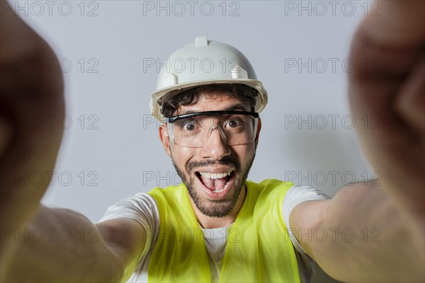 Smiling male engineer taking a selfie looking at camera. Funny builder engineer taking a selfie isolated