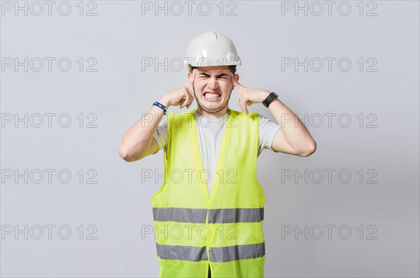 Young engineer covering his ears isolated
