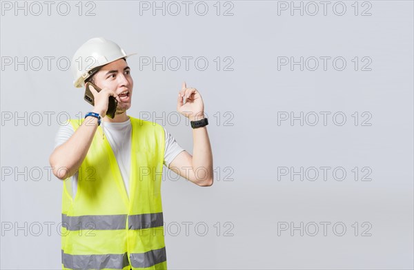 Builder engineer in vest talking on cell phone isolated. Civil engineer concept talking on cellphone isolated